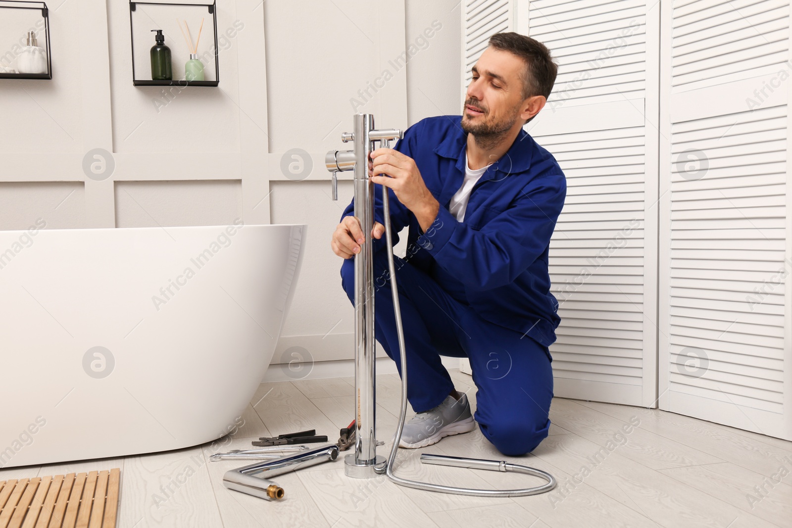 Photo of Professional plumber installing water tap in bathroom