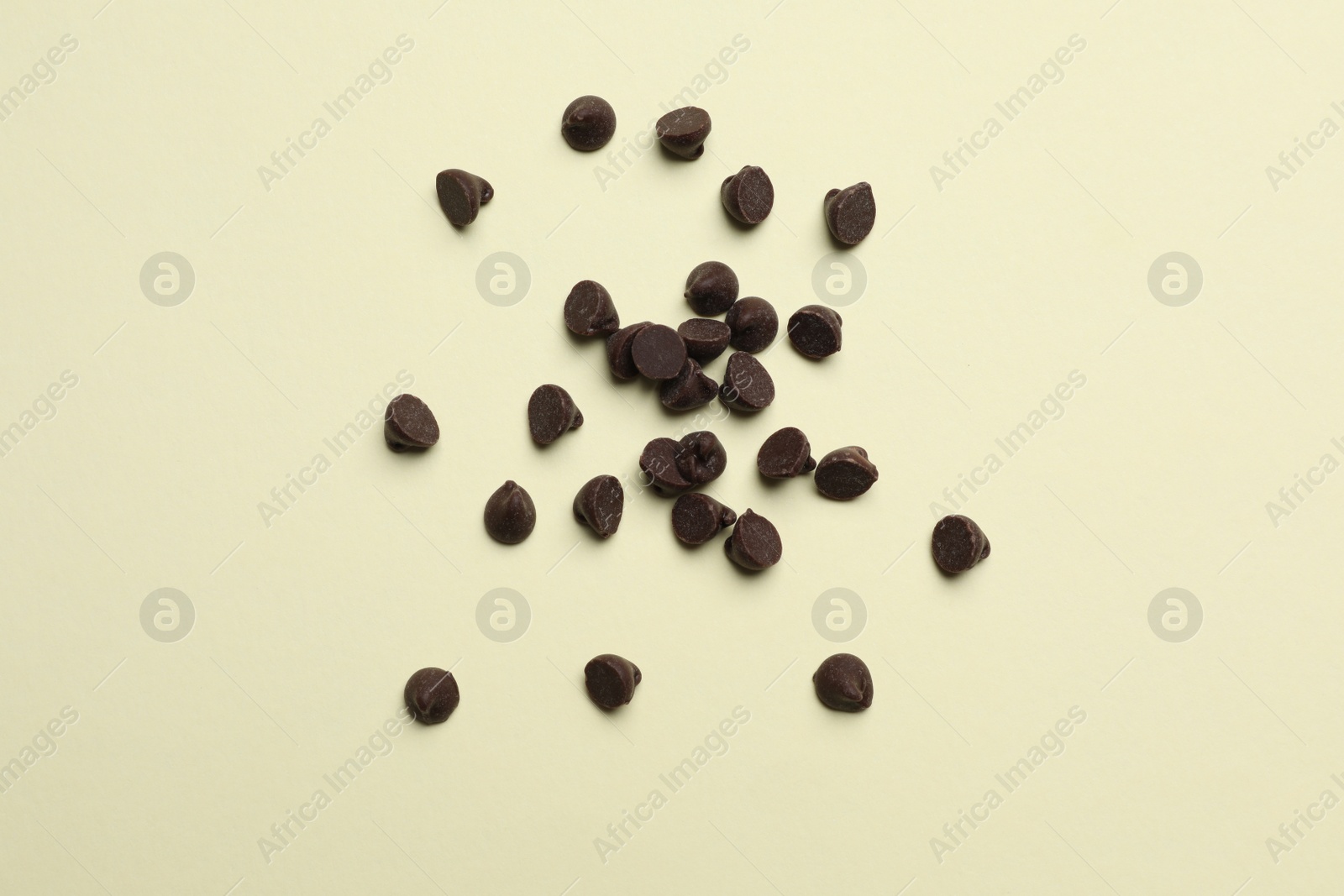 Photo of Delicious chocolate chips on beige background, top view