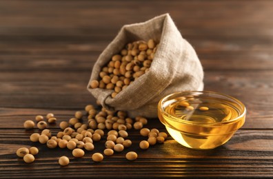 Photo of Bowl of oil and soybeans on wooden table
