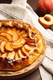 Photo of Delicious juicy peach pie on wooden table