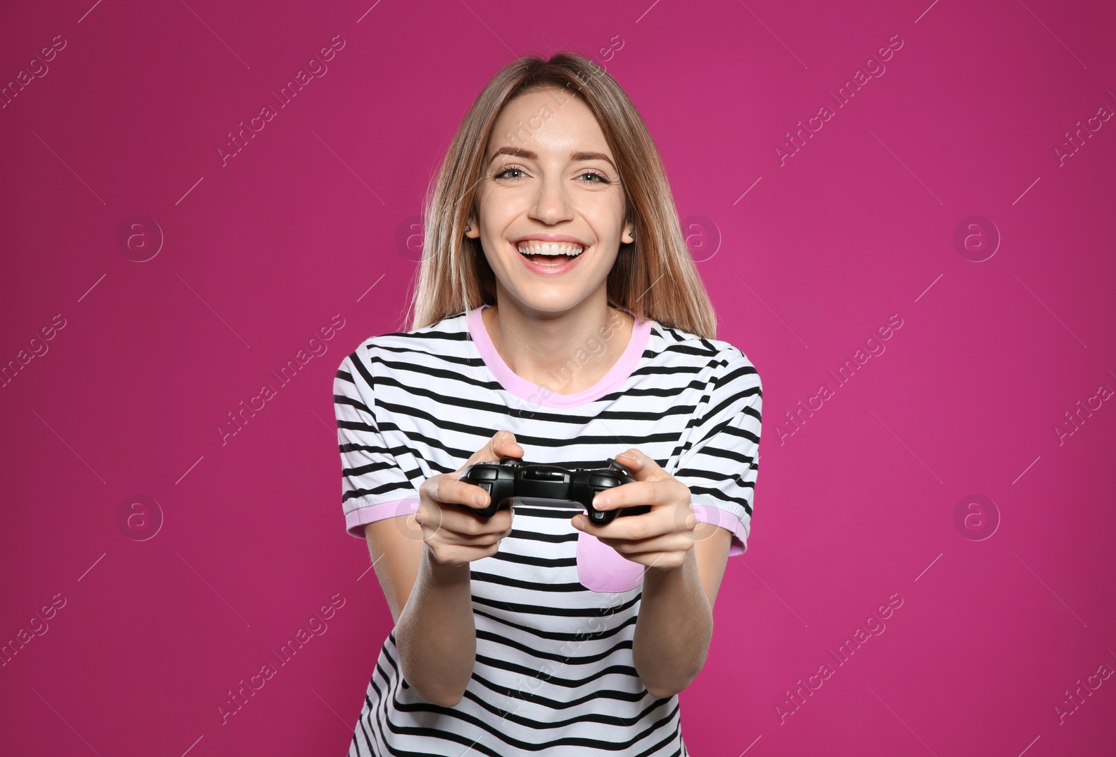 Photo of Emotional young woman playing video games with controller on color background