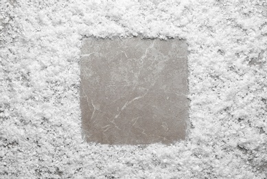 Photo of Frame made of snow on marble background, top view with space for text. Winter season