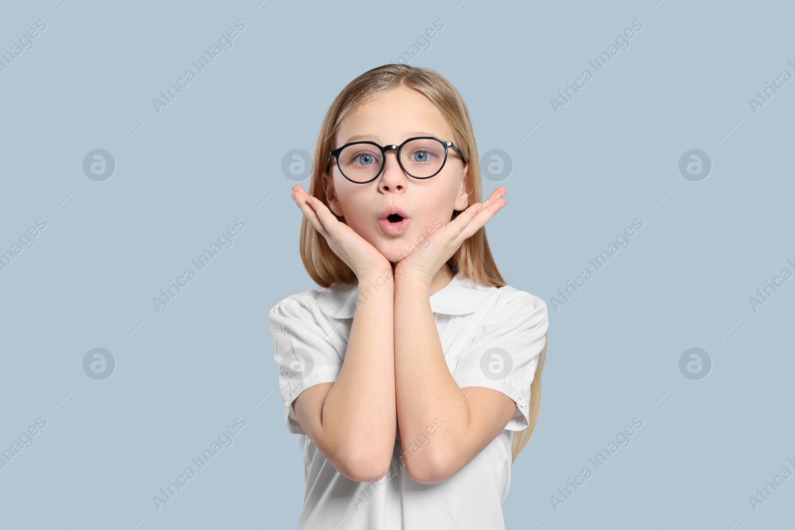 Photo of Portrait of emotional girl in glasses on light grey background