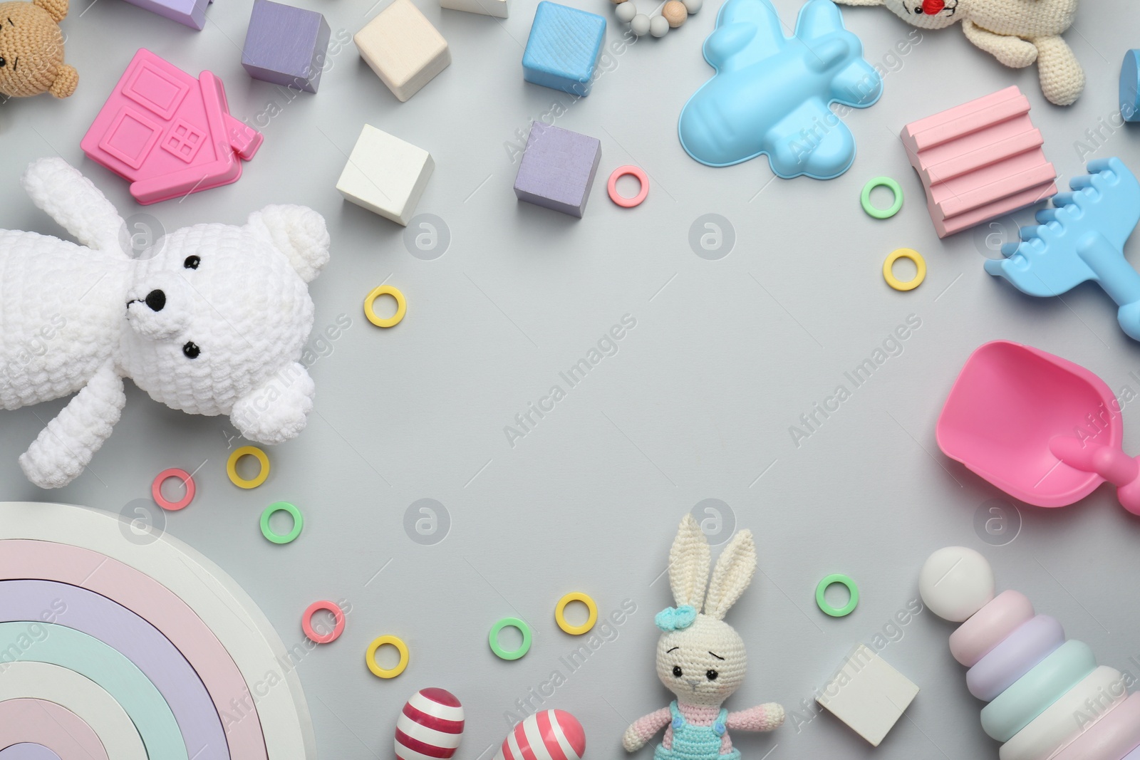 Photo of Frame of different children's toys on light grey background, flat lay. Space for text