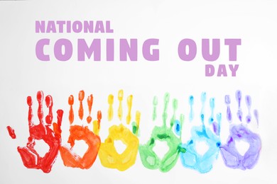 Image of National Coming Out day card with handprints in rainbow pride flag colors order and text on white background