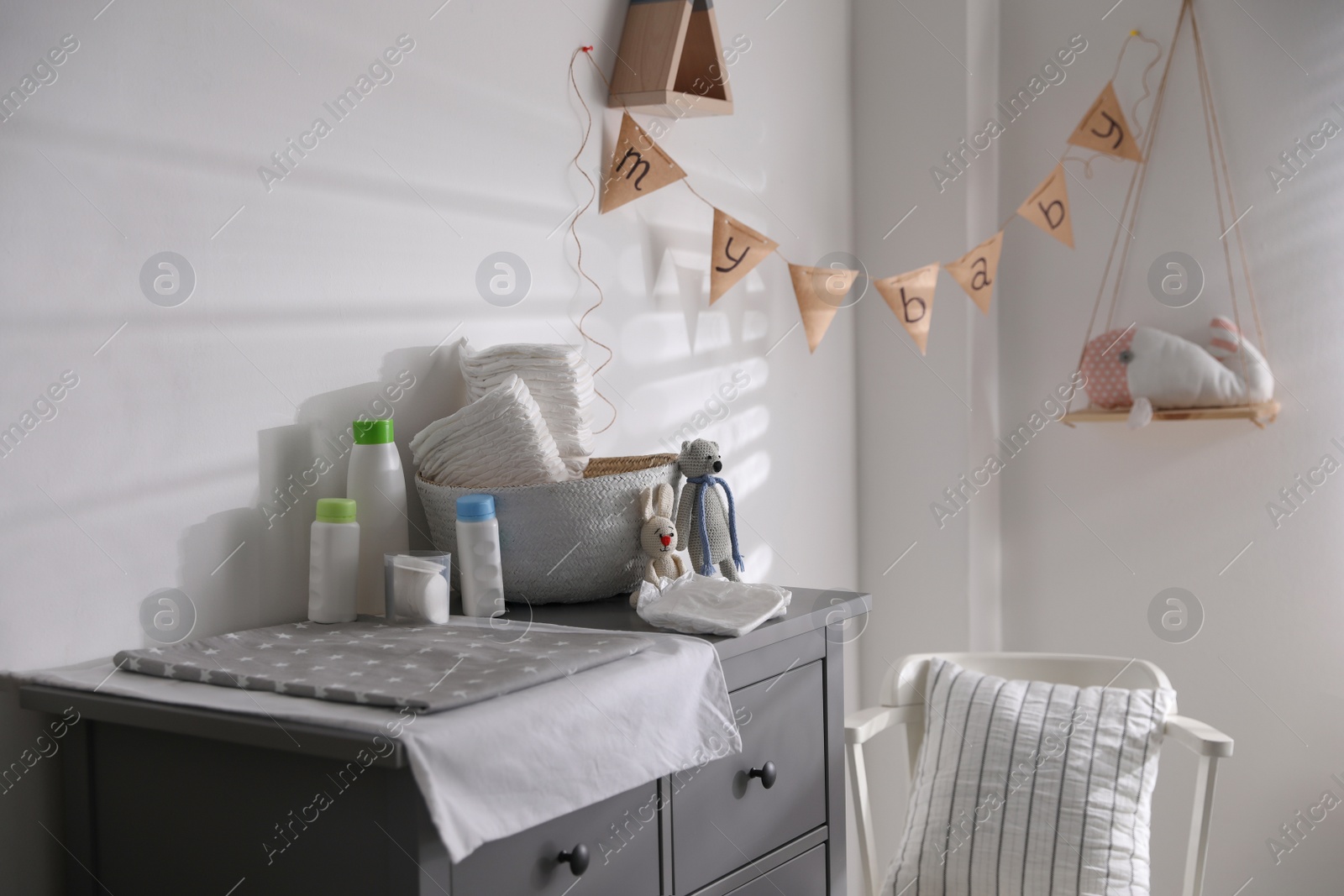 Photo of Chest of drawers with changing place in baby room. Interior design