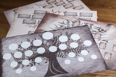 Photo of Blank family tree charts on wooden table, closeup
