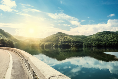 Image of Road trip. Beautiful view of asphalt highway along lake on sunny day 