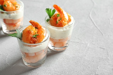 Photo of Glasses with fried shrimps and sauce on light background