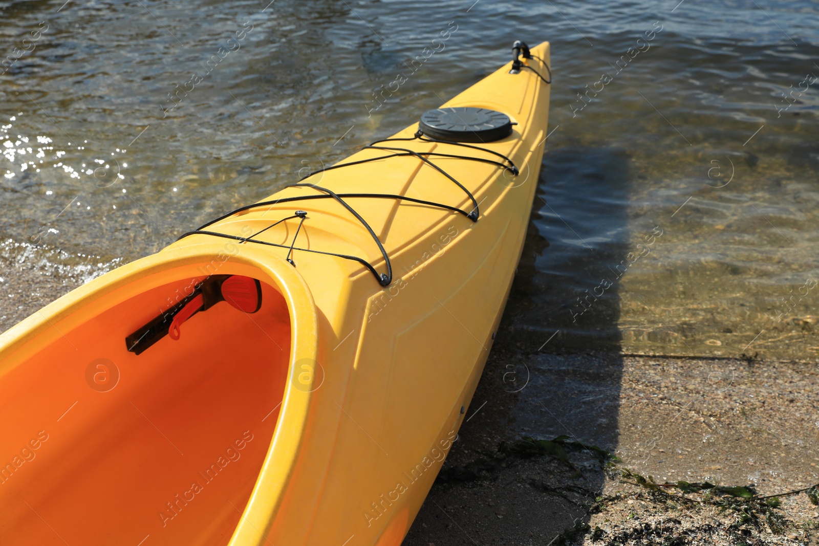 Photo of Yellow kayak on beach near river, closeup. Summer camp activity