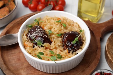 Photo of Bowl with sauerkraut and chicken on white table