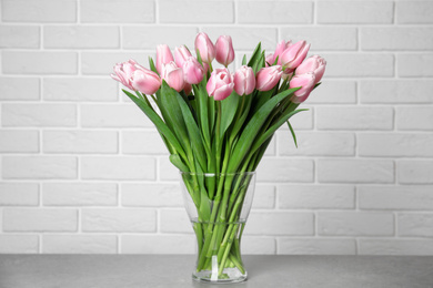 Photo of Beautiful pink spring tulips in vase on grey table