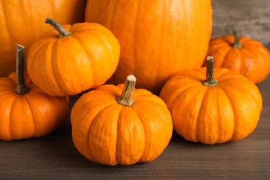 Photo of Fresh ripe pumpkins on wooden table, closeup