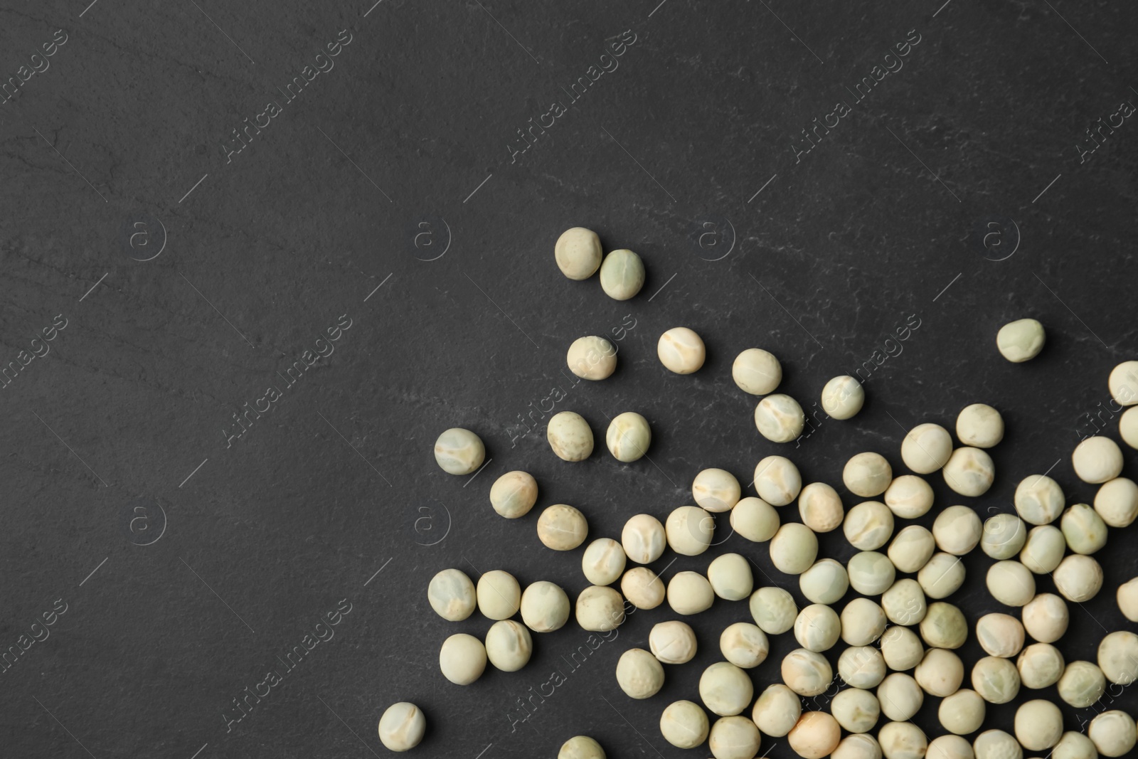 Photo of Raw dry peas and space for text on black background, flat lay. Vegetable seeds