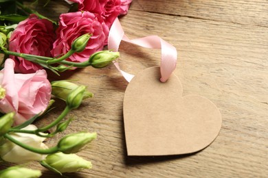 Photo of Happy Mother's Day. Beautiful flowers with blank heart shaped card on wooden table, closeup