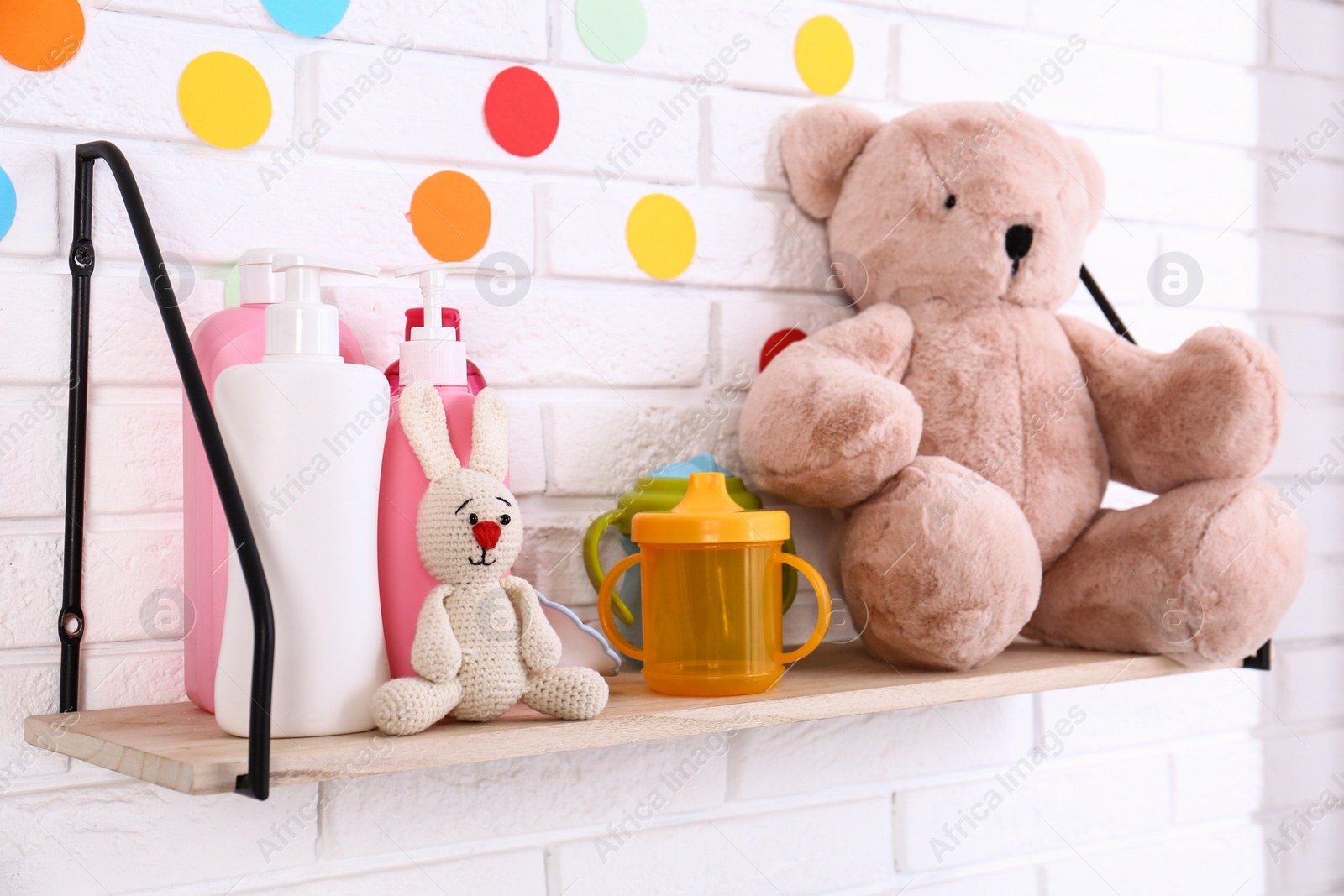 Photo of Baby accessories on shelf near white brick wall