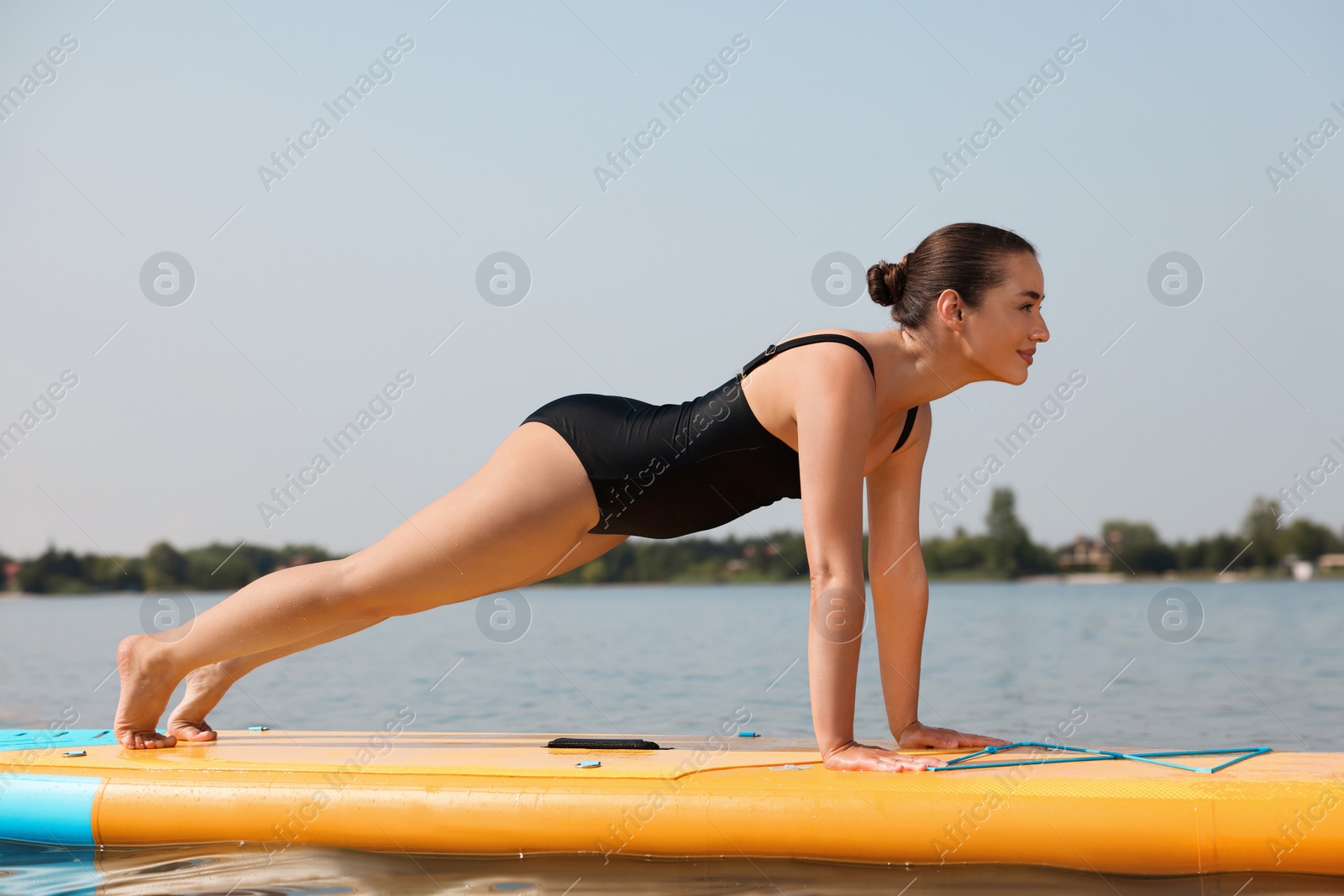 Photo of Woman practicing yoga on SUP board on river