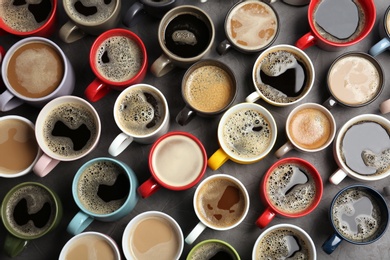 Many cups with tasty aromatic coffee on table, flat lay