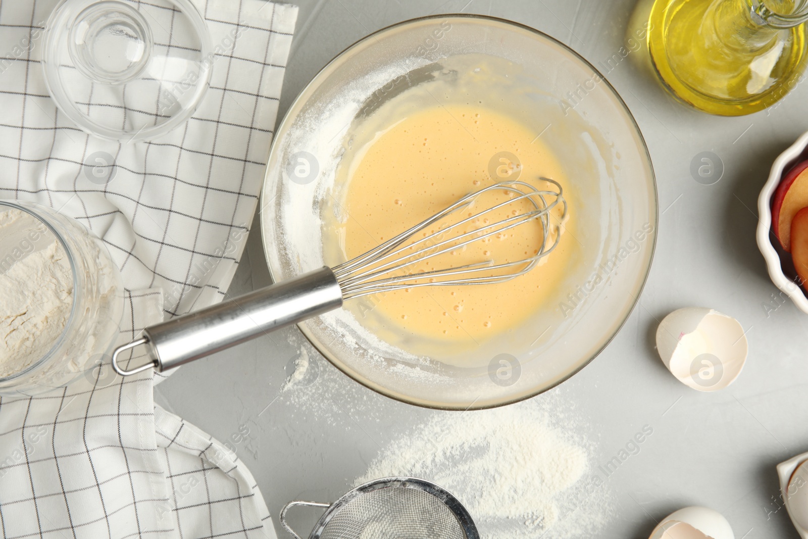 Photo of Dough and ingredients for cake on light grey table, flat lay