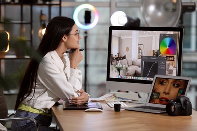 Professional retoucher working on computer and laptop in office