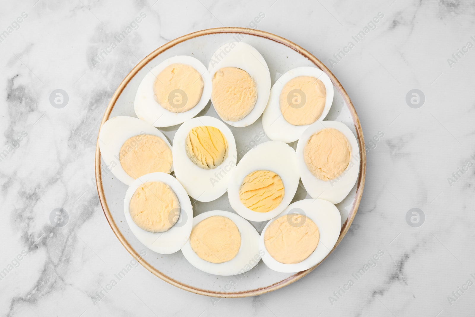 Photo of Fresh hard boiled eggs on white marble table, top view