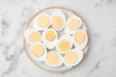 Fresh hard boiled eggs on white marble table, top view