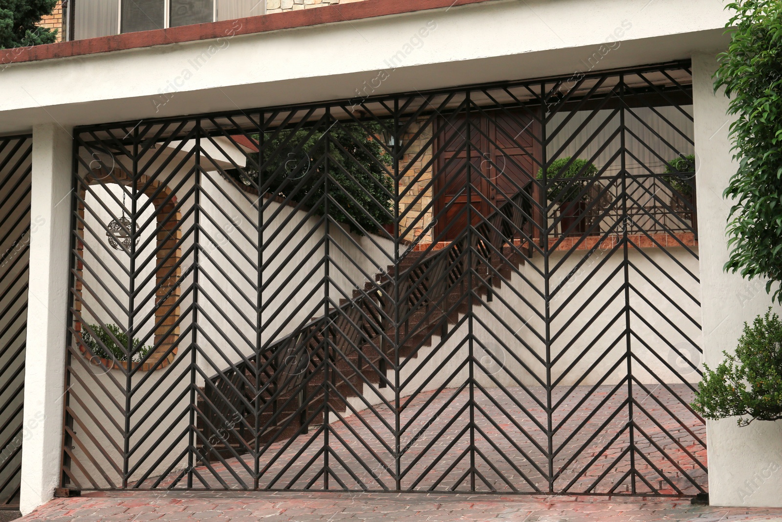 Photo of Closed metal gates near beautiful house on city street