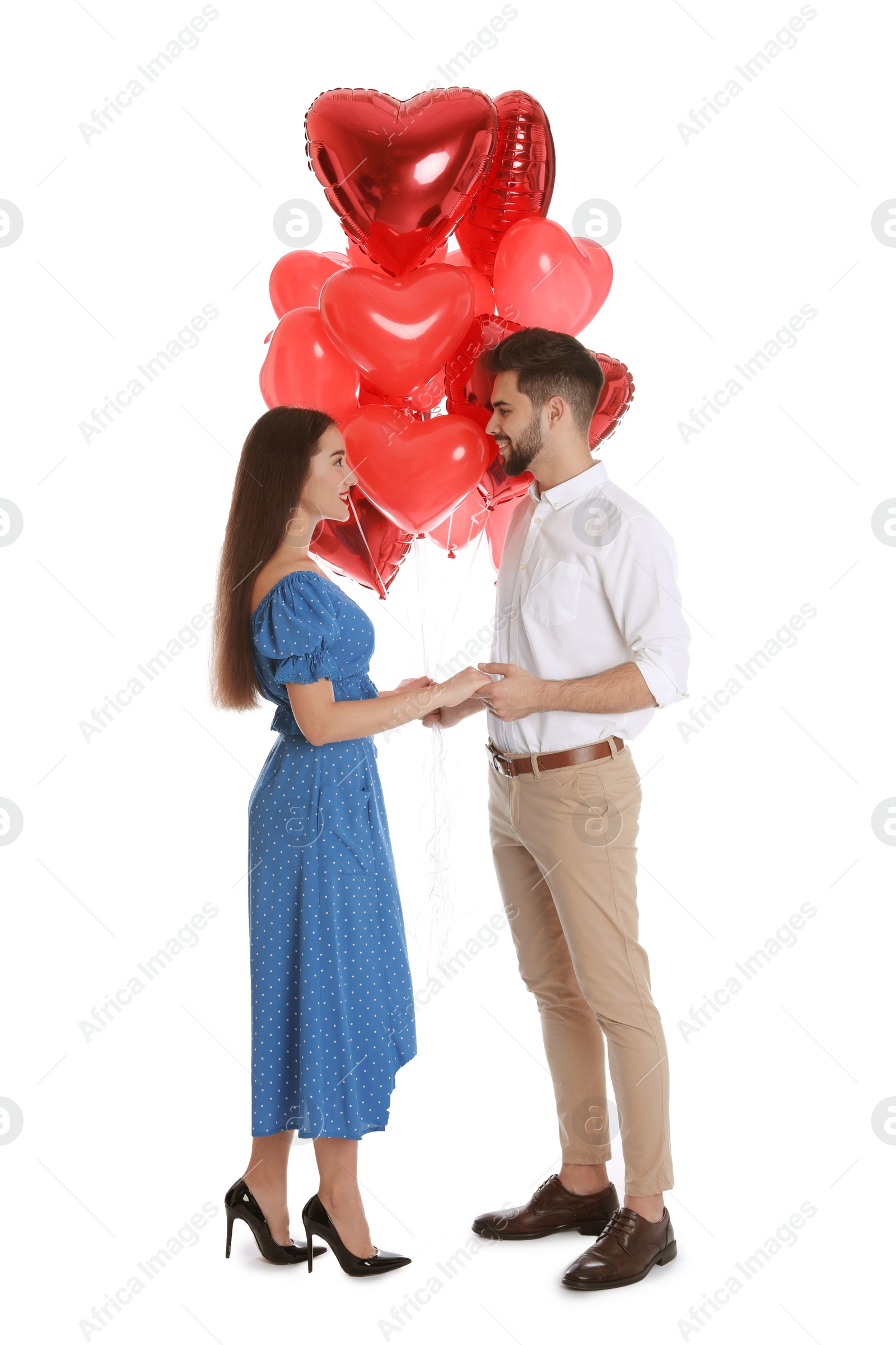 Photo of Happy young couple with heart shaped balloons isolated on white. Valentine's day celebration