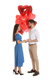 Photo of Happy young couple with heart shaped balloons isolated on white. Valentine's day celebration