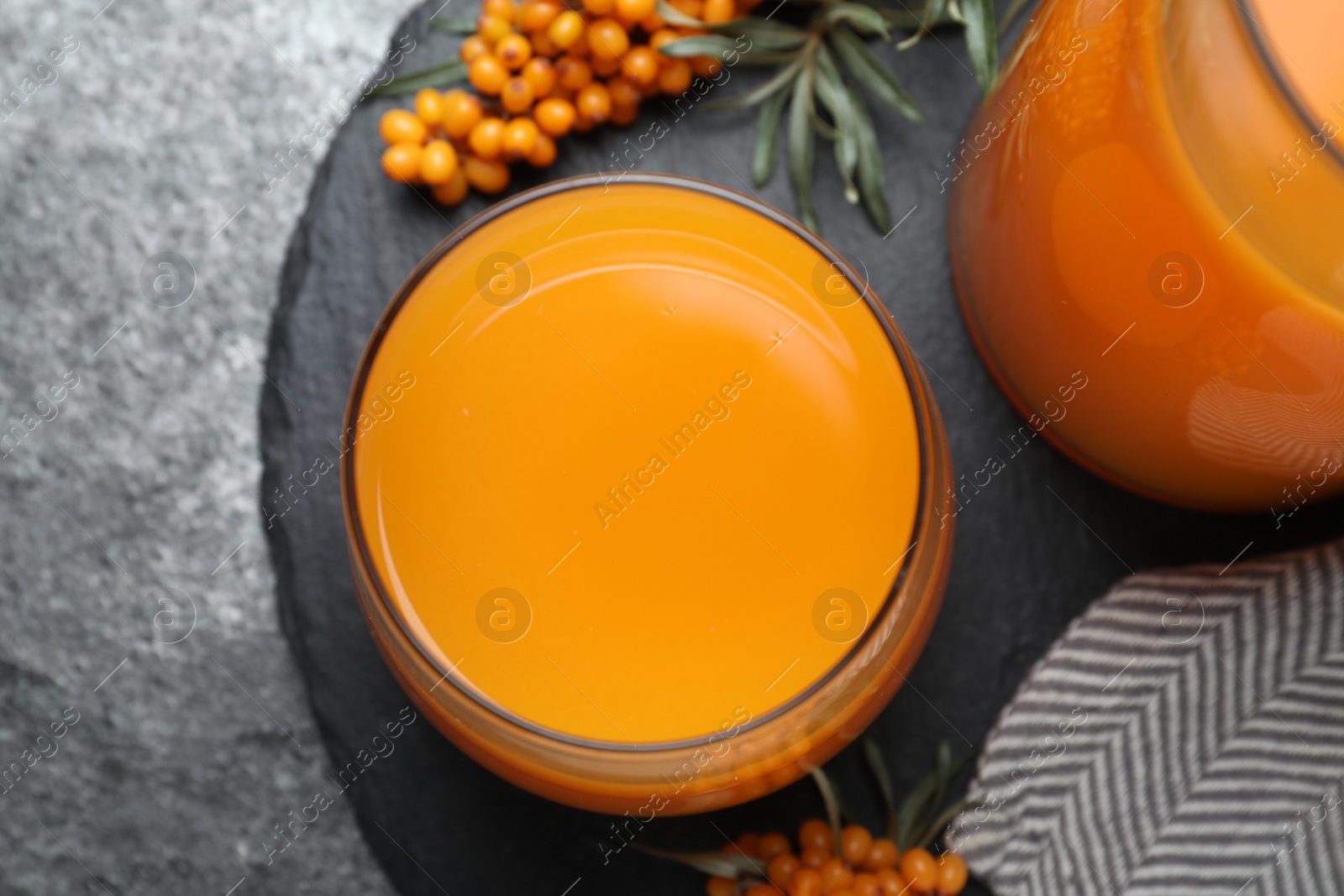 Photo of Delicious sea buckthorn juice on grey table, top view