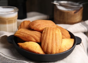 Delicious madeleine cakes in frying pan on table, closeup