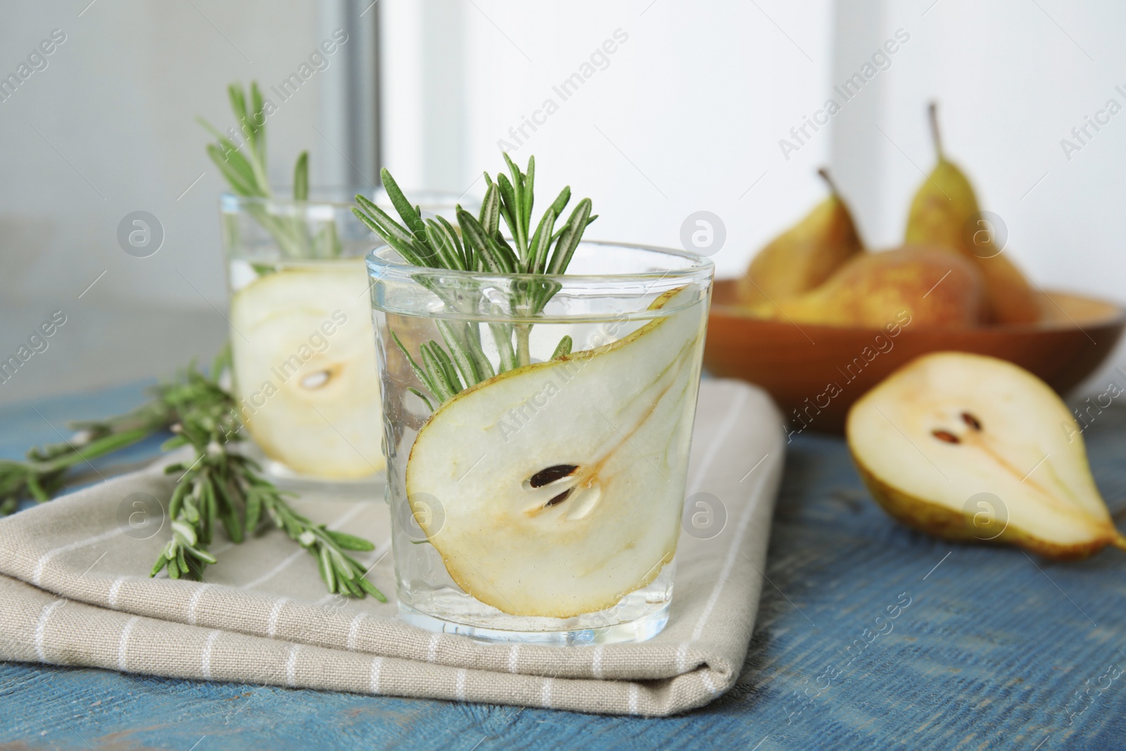 Photo of Refreshing pear cocktail with rosemary on table