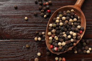 Photo of Aromatic spice. Different peppers in spoon on black table, top view. Space for text