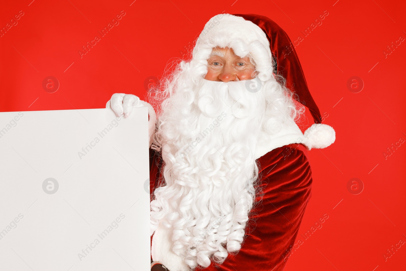 Photo of Authentic Santa Claus with blank banner on red background. Space for design