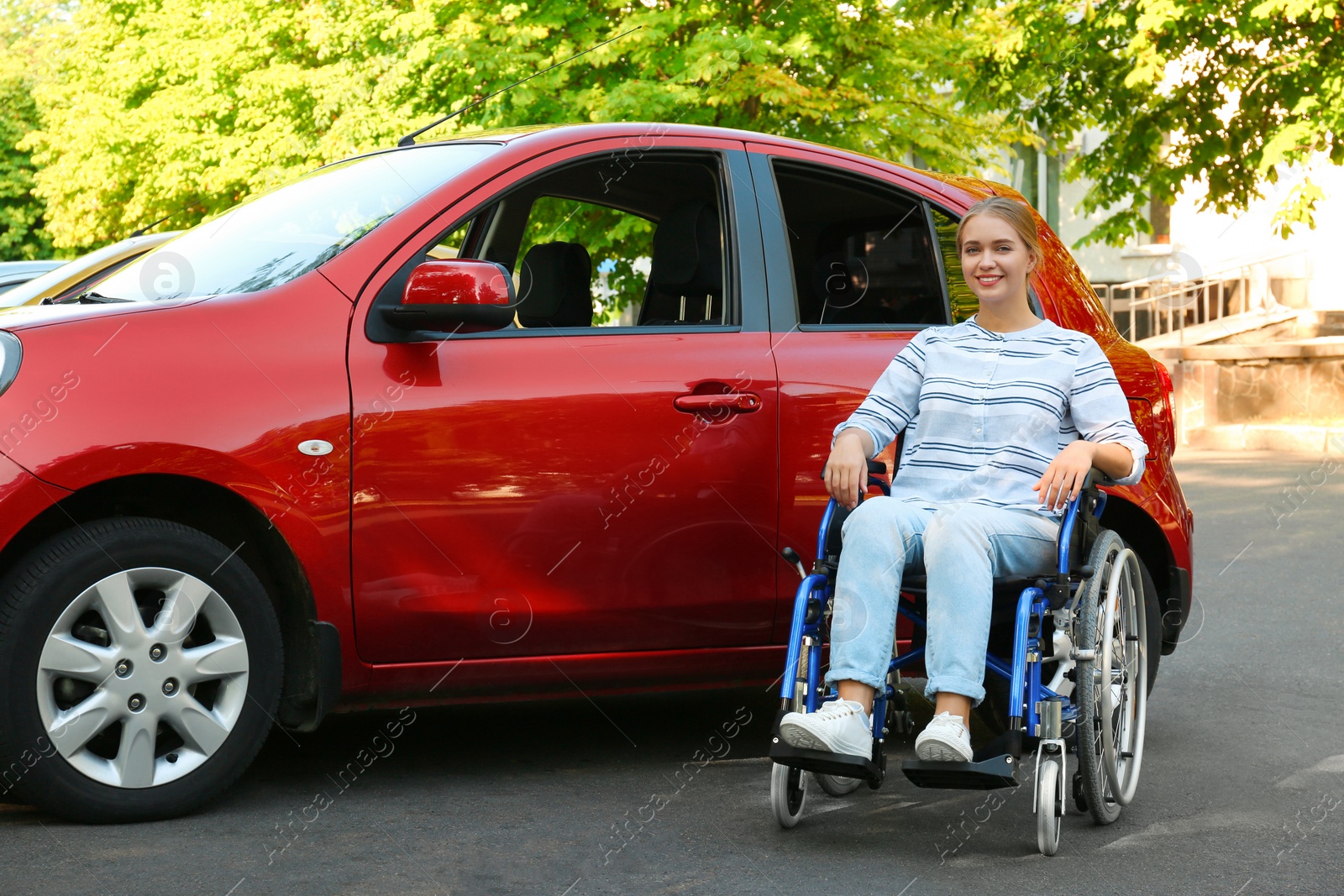 Photo of Young woman in wheelchair near car outdoors