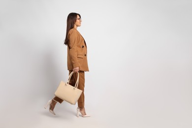 Young woman with stylish bag on white background