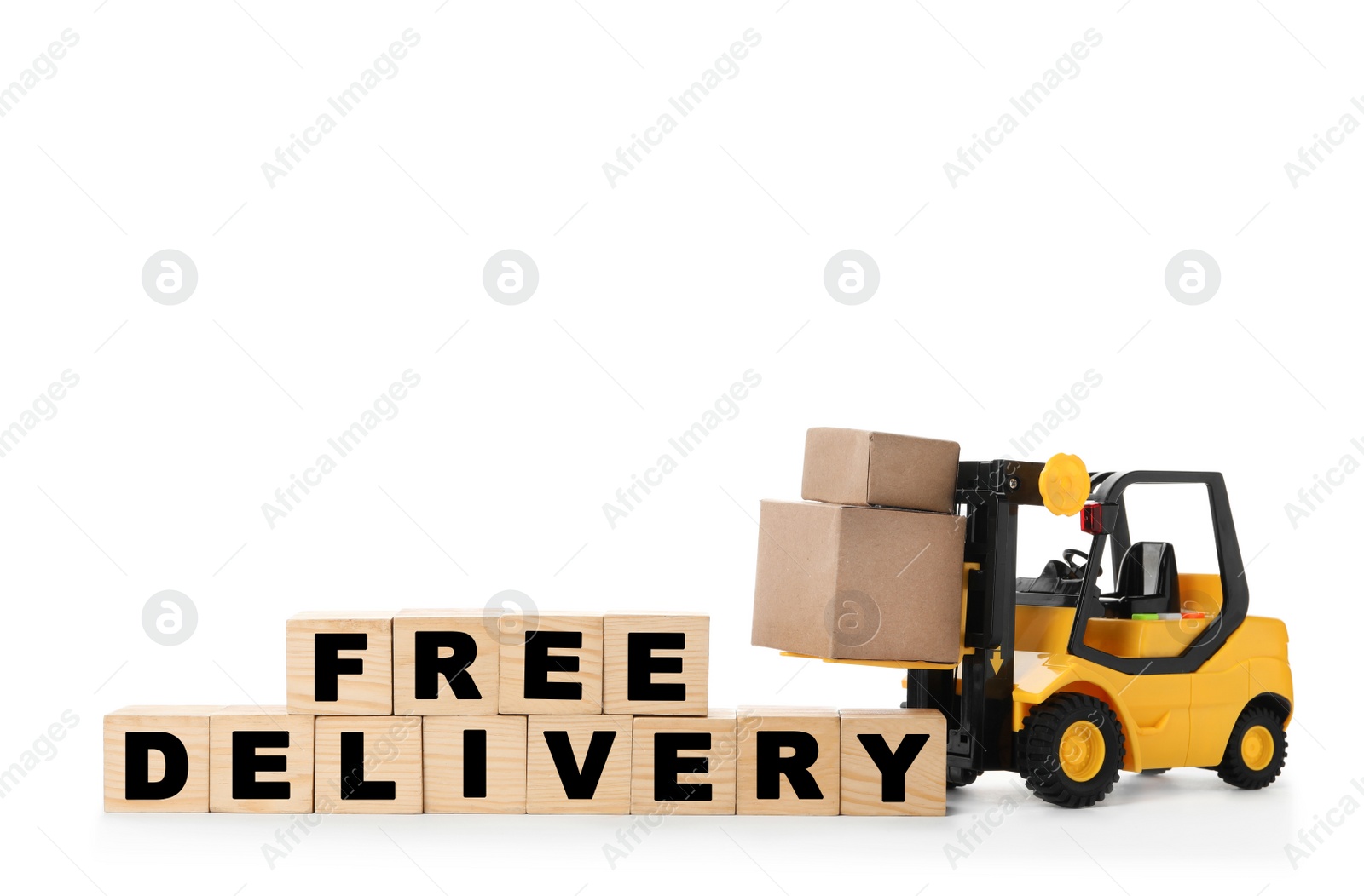 Photo of Toy forklift and cubes with words FREE DELIVERY isolated on white. Logistics and wholesale concept