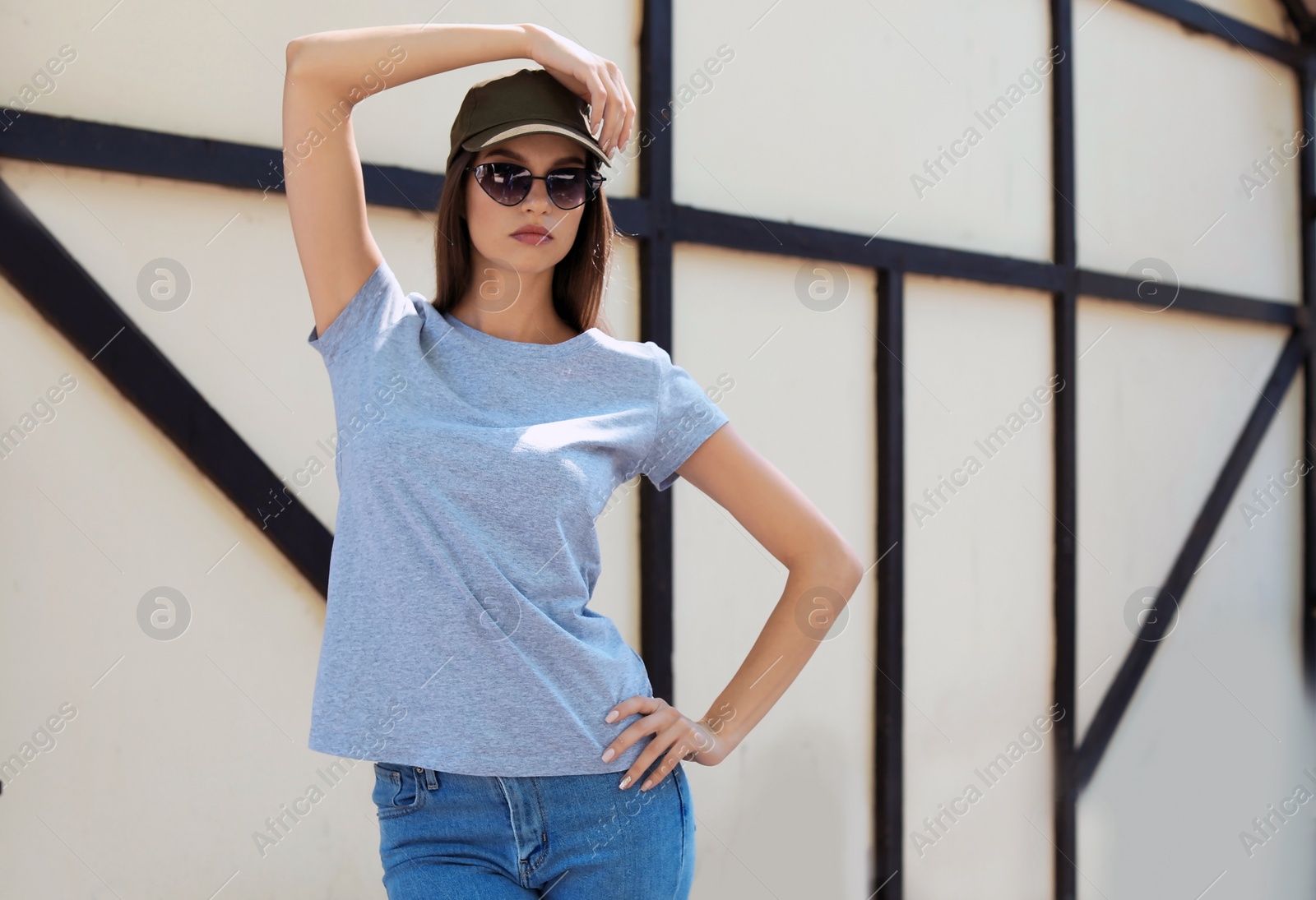 Photo of Young woman wearing gray t-shirt on street. Urban style