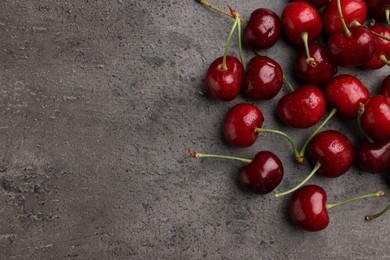 Photo of Many sweet cherries on grey table, flat lay. Space for text