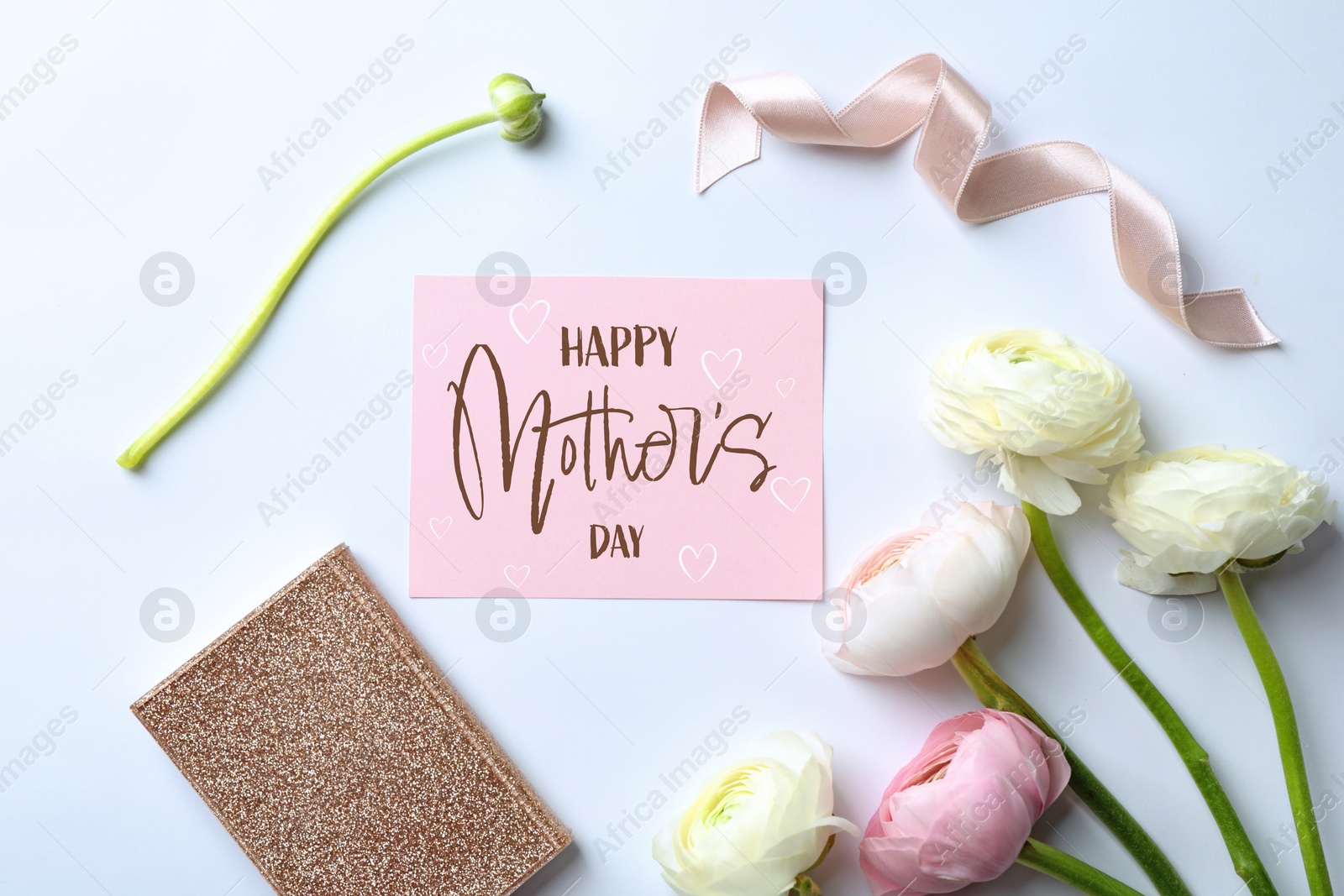 Image of Happy Mother's Day greeting card, beautiful ranunculus flowers, ribbon and notebook on light background, flat lay