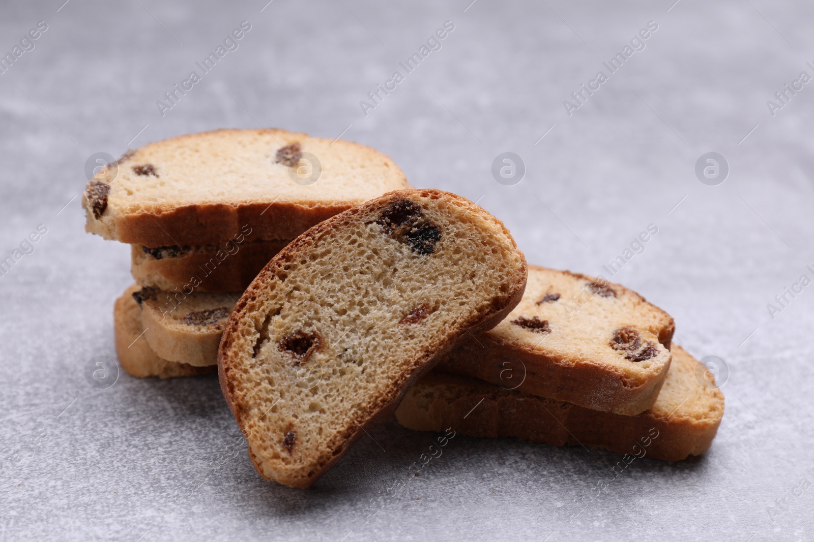 Photo of Sweet hard chuck crackers with raisins on light grey table, closeup