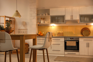 Modern kitchen interior with stylish wooden table. Space for text