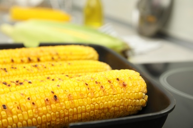 Cooking fresh corn cobs on grill pan, closeup