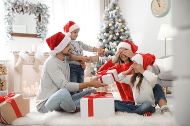 Happy family with children and Christmas gifts on floor at home