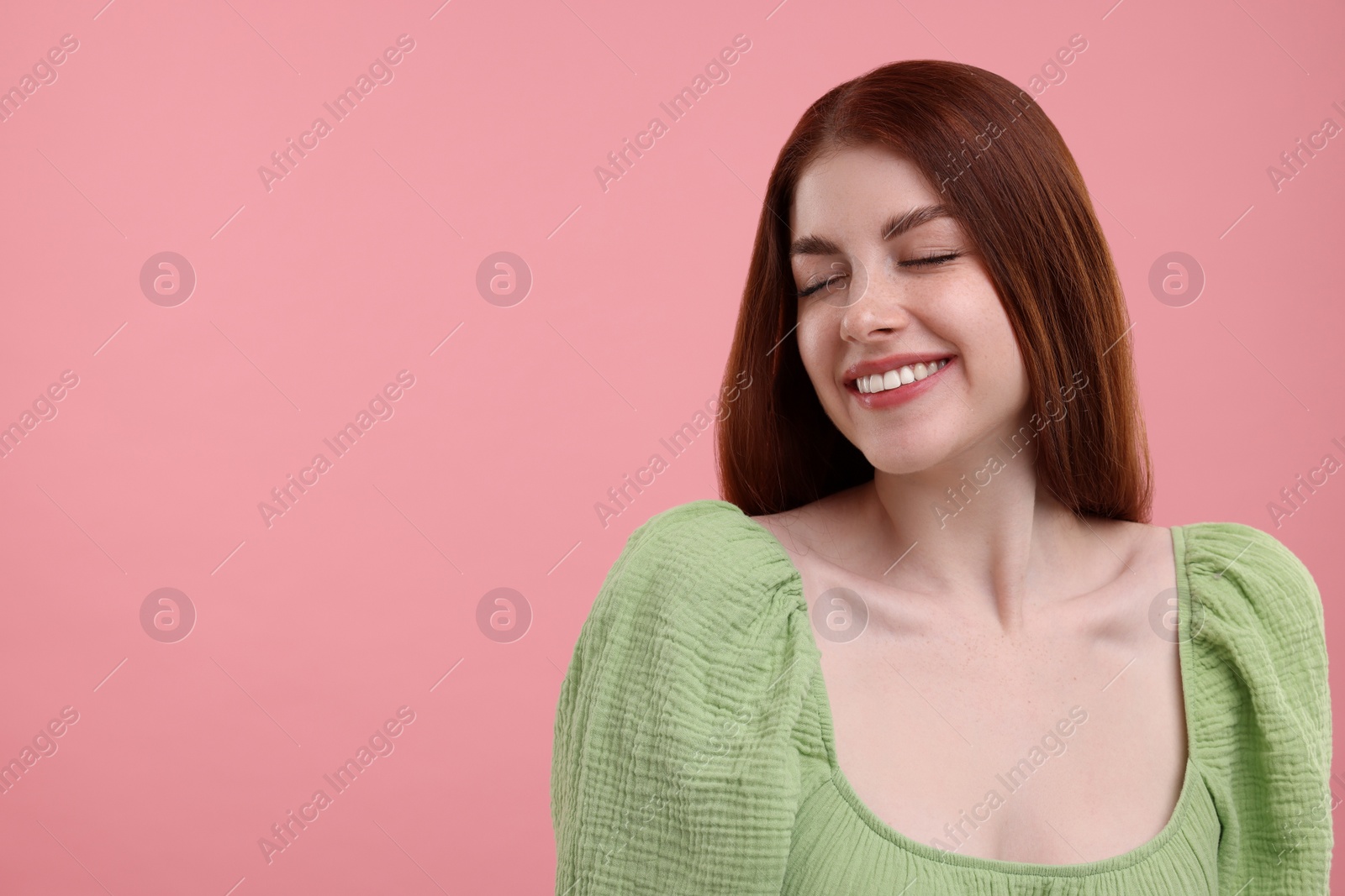 Photo of Portrait of smiling woman with freckles on pink background. Space for text