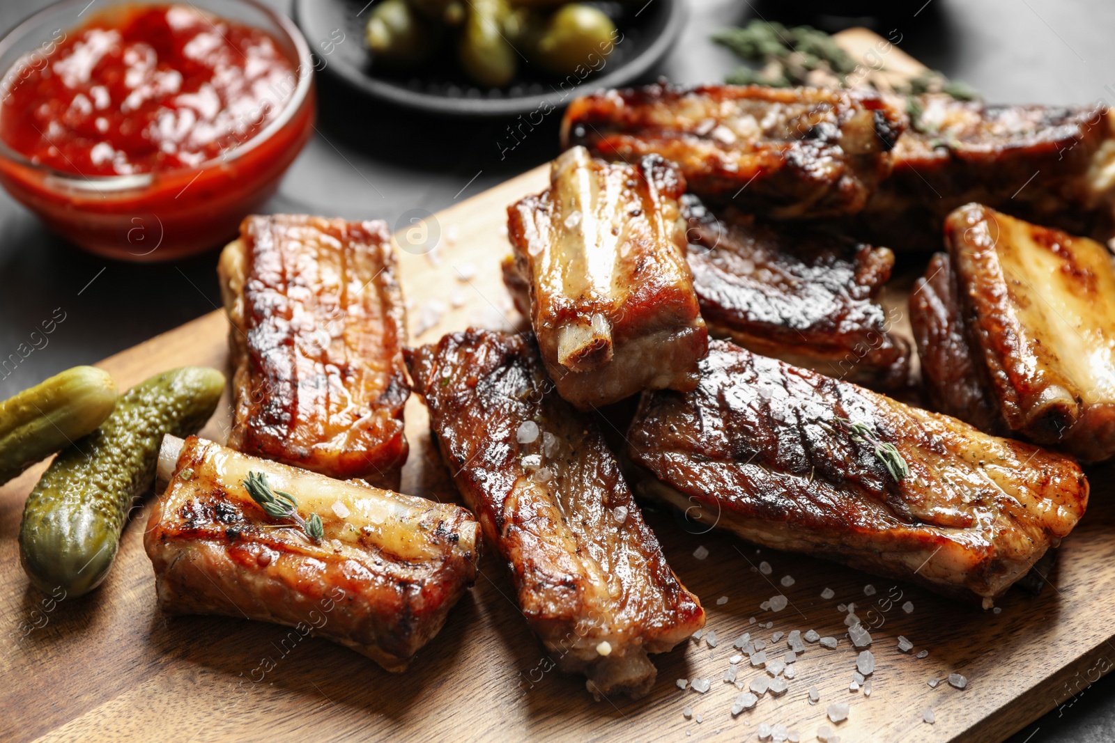 Photo of Delicious grilled ribs served on table, closeup