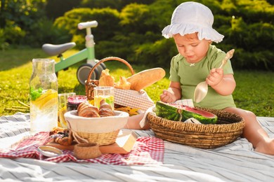 Cute child eating watermelon on picnic blanket in garden