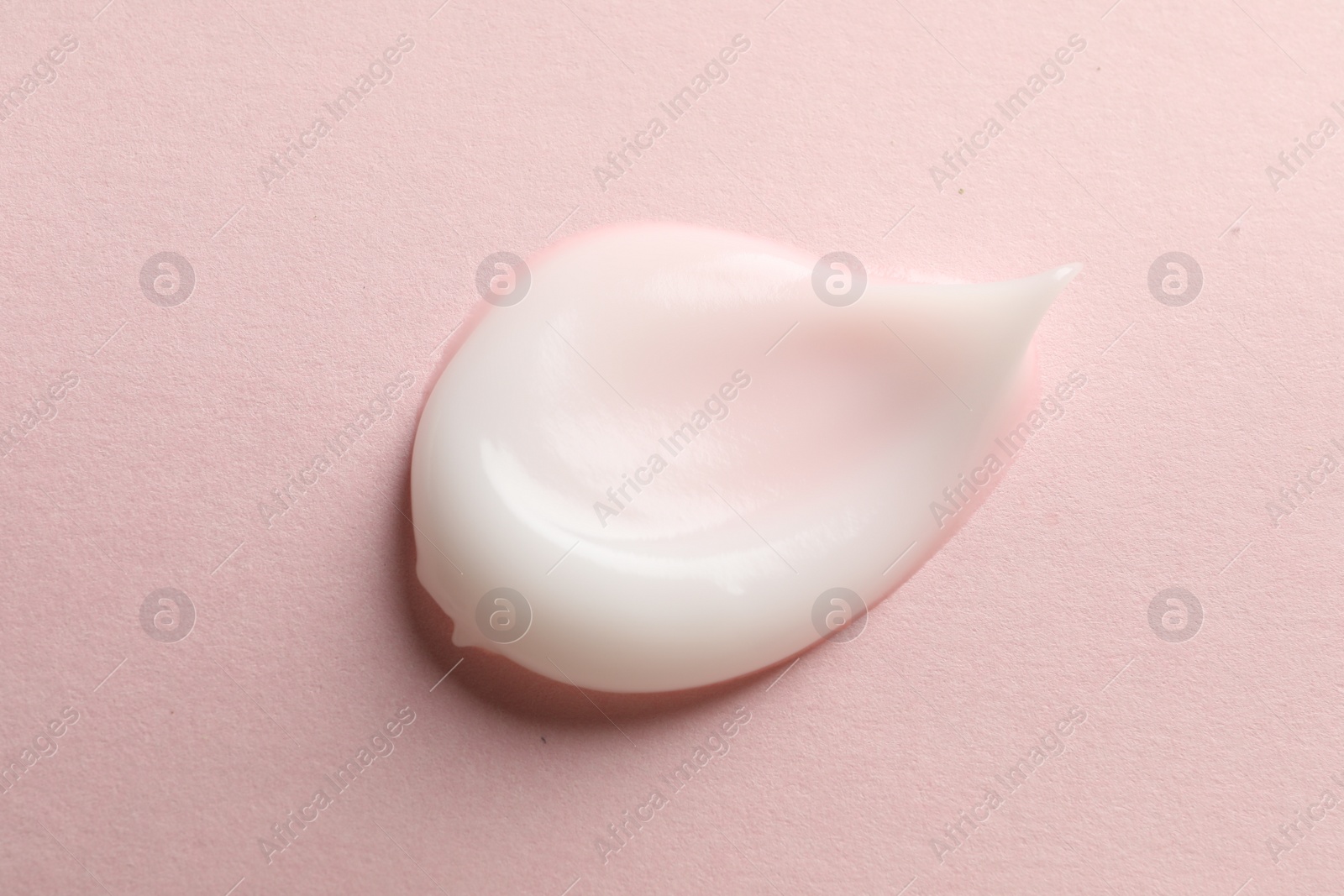 Photo of Sample of face cream on pink background, top view