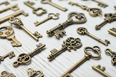 Photo of Old vintage keys on wooden background, closeup
