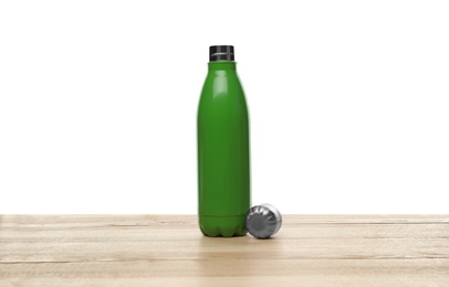 Photo of Stylish thermo bottle on wooden table against white background